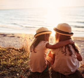 Two friends sitting on cliff and looking to the future